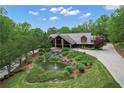 Inviting log-style home with a covered porch and beautifully landscaped pond at 14501 Woolsey Rd, Hampton, GA 30228