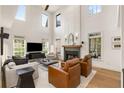 Bright living room with a high ceiling, fireplace, and large windows, offering ample natural light at 1701 Clay Brooke Se Ct, Smyrna, GA 30082