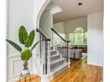 Bright foyer featuring hardwood floors, staircase, and a view into the living room with large windows at 1625 Hawkins Cove Trl, Roswell, GA 30076