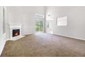 Bright living room featuring a fireplace, sliding glass doors, and plush carpet at 6595 Browns Mill Ferry Dr, Lithonia, GA 30038