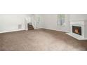 Cozy living room with plush carpet and a fireplace, perfect for relaxation at 6595 Browns Mill Ferry Dr, Lithonia, GA 30038