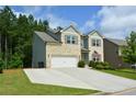 Charming two-story brick home with a well-manicured lawn and a two-car garage at 302 Aspen Valley Ln, Dallas, GA 30157