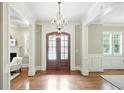 Elegant foyer showcasing beautiful hardwood floors, a stunning chandelier, and natural light at 400 Mabry Pl, Atlanta, GA 30319