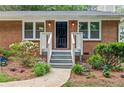 Close-up view of a charming front porch with well-maintained landscaping and a classic brick facade at 3119 Medley Rdg, Decatur, GA 30033