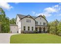 New construction two-story home with white siding, black trim, attached garage, and landscaped front yard at 4525 Aiden Way, Cumming, GA 30041