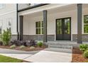 Covered front porch featuring brick base, black support columns, and a double front door with glass inserts at 4525 Aiden Way, Cumming, GA 30041