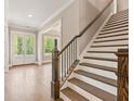 Foyer with staircase, hardwood floors, and a glass paneled front door that provides natural light at 4525 Aiden Way, Cumming, GA 30041