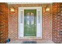 Elegant front door with decorative glass inserts and sidelights framed by sconces at 2930 Heather Stone Way, Lawrenceville, GA 30043