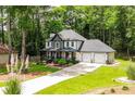 Two-story home with a landscaped lawn and an attached two-car garage and a charming front porch with decorative trim at 3139 Fairview Dr, Snellville, GA 30078