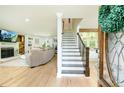 Open living room featuring wood floors, fireplace, staircase, and a view of the kitchen and entry way at 3139 Fairview Dr, Snellville, GA 30078