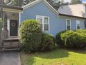 Close-up of a quaint single-Gathering home, with blue siding, surrounded by neatly trimmed bushes and a small lawn at 4059 Heritage Valley Ct, Norcross, GA 30093