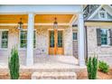 Charming brick home featuring a covered front porch with wooden ceiling and double door entry at 410 Iroquois Ct, Covington, GA 30014
