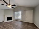 Bright living room with fireplace, wood floors, ceiling fan, and vaulted ceiling at 155 Fairclift Dr, Covington, GA 30016