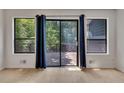 Living room featuring hardwood floors, bright windows, blue curtains and sliding glass door to the outdoor deck at 178 Castleair Ne Dr, Kennesaw, GA 30144
