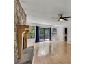 Bright living room with hardwood floors, stone fireplace, ceiling fan and large sliding doors to the deck at 178 Castleair Ne Dr, Kennesaw, GA 30144