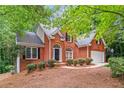 Attractive brick home with a two-car garage, front yard with mature shrubbery at 1765 Redbud Way, Cumming, GA 30041