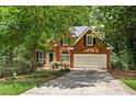 Beautiful two-story brick home featuring an attached two car garage and lush landscaping at 1765 Redbud Way, Cumming, GA 30041