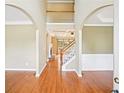 View into the home's foyer featuring hardwood floors, high ceilings and a staircase to the second level at 2359 Saint Kennedy Ln, Buford, GA 30518