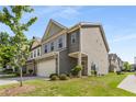 Charming townhome featuring a two-car garage, lush landscaping, and craftsman-style details at 2829 Wild Laurel Ct, Norcross, GA 30071