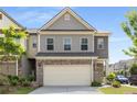 Beautiful townhome featuring brick accents, a two-car garage, and lush landscaping at 2829 Wild Laurel Ct, Norcross, GA 30071