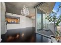 Open-concept living area with dark hardwood floors, a chandelier, and sliding glass door to a balcony at 3324 Peachtree Ne Rd # 2718, Atlanta, GA 30326