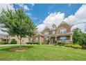 Lovely two-story brick home with a manicured front lawn, trees, and welcoming porch at 5515 Cheatam Ave, Cumming, GA 30040
