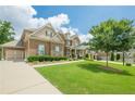 Lovely two-story brick home with a three car garage, long driveway and sprawling green lawn at 5515 Cheatam Ave, Cumming, GA 30040