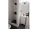 Modern bathroom featuring white subway tile, a black shower head, black accents, and hexagon tile at 2037 Brannen Se Rd, Atlanta, GA 30316