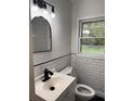 Bathroom featuring white subway tile, black accents, and a large window offering natural light at 2037 Brannen Se Rd, Atlanta, GA 30316