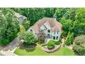 Stunning aerial view of the home showcasing its architectural design and mature landscaping at 4115 Falls Ridge Dr, Johns Creek, GA 30022
