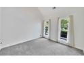 Versatile empty room showcasing neutral carpet, natural light, and serene backyard views at 4206 Moccasin Trl, Woodstock, GA 30189