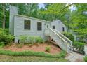 Charming exterior with well-manicured lawn and inviting staircase leading to the front door, surrounded by trees at 7025 Stone Wood Nw Dr, Kennesaw, GA 30152