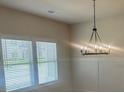 Bright dining room with a modern chandelier and a large window with natural light at 118 Longhorn Way, Auburn, GA 30011
