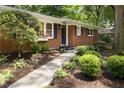 Charming brick home with dark shutters and a manicured lawn, enhanced by landscape lighting at 1597 Fama Ne Dr, Atlanta, GA 30329