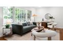 Well-lit living room with modern furniture, neutral rug, and views of the lush backyard at 1597 Fama Ne Dr, Atlanta, GA 30329