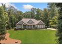 Beautifully landscaped home with a sprawling green lawn and mature trees at 208 Wilshire Ter, White, GA 30184