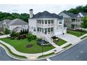 Beautiful two-story brick home featuring dual porches, manicured lawn, attached garage, and professional landscaping at 4503 Atley Woods Se Dr, Atlanta, GA 30339