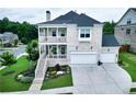 Beautiful two-story brick home featuring dual porches, manicured lawn, attached garage, and professional landscaping at 4503 Atley Woods Se Dr, Atlanta, GA 30339