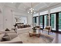 Open-concept living room with access to outdoor balcony, coffered ceilings, and modern decor at 821 Camden Park Ct, Atlanta, GA 30342