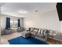 Bright and airy living room featuring a plush gray sofa, comfortable chairs, and large window with natural light at 368 Rankin Cir, Mcdonough, GA 30253