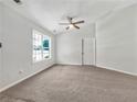 Clean, empty bedroom with plush carpet, ceiling fan, and bright natural light from large windows at 256 Prometheous Way, Rockmart, GA 30153