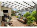 Relaxing covered patio area with comfortable seating, a TV, and lush greenery at 2610 Links End, Roswell, GA 30076
