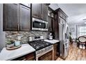 Modern kitchen with stainless steel appliances and dark cabinets at 3064 Baymount Way, Lawrenceville, GA 30043