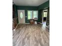 Bright living room featuring modern flooring, a white door, and green walls, offering a cozy space at 702 Moon Rd, Lawrenceville, GA 30046