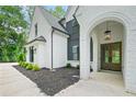 Charming front entrance with stone archway and custom wood double doors at 103 Maddox Rd, Buford, GA 30518