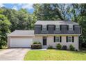Charming two-story home featuring a gray brick facade, black shutters, and a well-maintained front lawn at 120 E Cainwood E Ct, Atlanta, GA 30349