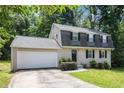 Charming two-story home featuring a gray brick facade, black shutters, and an attached garage at 120 E Cainwood E Ct, Atlanta, GA 30349