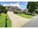 View of a brick home with a long driveway on a grassy lot, neighborhood street view at 412 Middlebrooke St, Canton, GA 30115