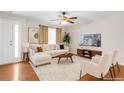 Bright living room with hardwood floors, stylish furniture, a ceiling fan, and a large window at 5807 Mitchell Chase Trl, Mableton, GA 30126