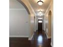 Inviting hallway featuring hardwood floors, archways, and stylish lighting fixtures at 330 La Perla Dr, Sugar Hill, GA 30518